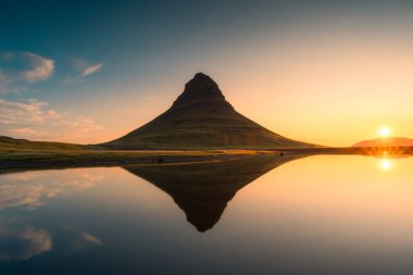 İzlanda, Snaefellsnes yarımadasında güneş doğarken gölün yansımasıyla simetri volkanı Kirkjufell 'in güzel manzarası. 