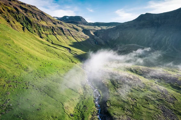 冰岛夏季的空中俯瞰着有着火山山和遥远荒野中的雾气的古绿色山谷 — 图库照片