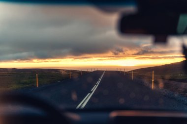 Otoyolda araba sürerken ve yazın kırsalda gün batımında parlarken.