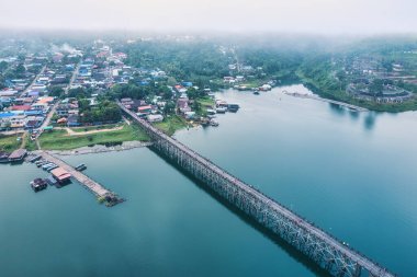 Geleneksel Mon köyünün Sangkhlaburi, Kanchanaburi, Tayland 'daki barajda sabah sisli ve ahşap Mon köprüsü manzarası.