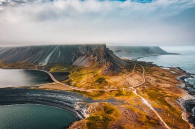 Majestic Eystrahorn burnu ya da Krossasnesfall dağ sırasının havadan görünüşü yaz mevsiminde İzlanda 'nın doğusundaki yarımadada sisli bir şekilde kaplıdır.