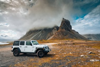 Eystrahorn ya da Krossasnesfjall dağının sisli manzarası ve yazın İzlanda 'nın doğusunda Atlantik Okyanusu' nun kıyısına park edilmiş 4wd araba.