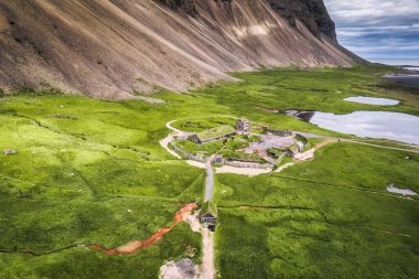 Terk Edilmiş Kırsal Viking Köyü 'nün havadan görünüşü. Yazın İzlanda, Stokksnes yarımadasında Vestrahorn Dağı' nın vahşi doğası.