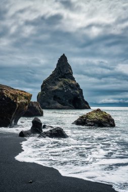 Reynisdragar 'ın karamsar doğal kaya oluşumunun dramatik manzarası Reynisfjara' nın Atlantik Okyanusu 'ndaki kara kumsalda İzlanda' nın güneyindeki Vik 'te.
