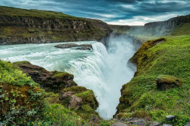 Gullfoss ya da Golden Falls 'un panoramik manzarası Hvita nehrinden akan güçlü şelale ve İzlanda' nın güneybatısındaki kasvetli gökyüzü