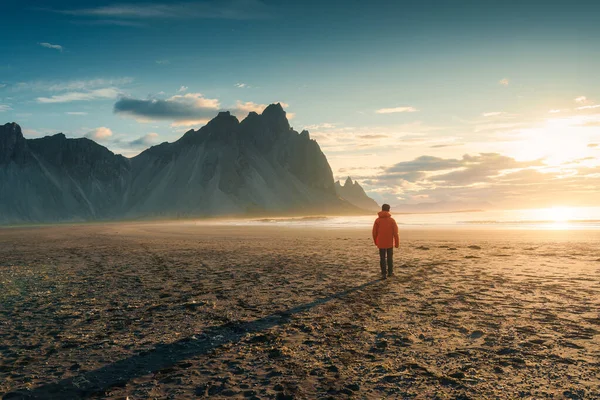 アイスランドのストークスネス半島で夏に黒い砂浜を歩く観光客とベストラホーン山の上に日の出の美しい景色 — ストック写真
