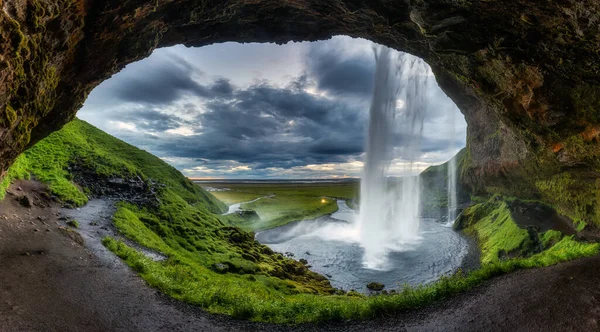 在冰岛南部阴郁的夏天 美丽的天然洞穴 有着雪崩的瀑布和茂密的田野 — 图库照片