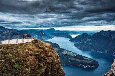 Fronalpstock 'un zirveye çıkan çapraz ve turist manzarası ve İsviçre' nin Schwyz kentindeki Lucerne Gölü 'ne bakan kasvetli gökyüzü.