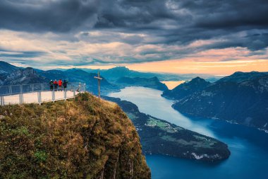 Fronalpstock 'un zirveye çıkan çapraz ve turist manzarası ve İsviçre' nin Schwyz kentindeki Lucerne Gölü 'ne bakan kasvetli gökyüzü.