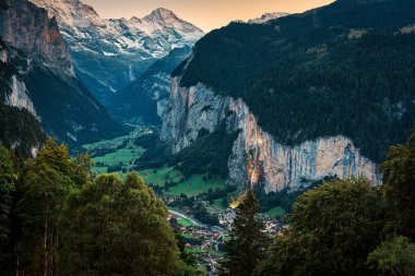 Wengen dağ köyünden güzel bir manzara ve İsviçre 'nin Bern şehrinde alacakaranlıkta Lauterbrunnen vadisini aydınlattı.
