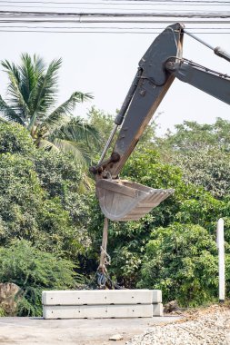 Backhoe inşaat alanındaki çimento bloğunu kaldırarak çalışıyor