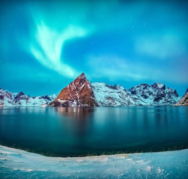 Norveç 'in Lofoten Adaları' ndaki Hamnoy köyünün kıyı şeridi üzerinde parlayan Aurora borealis 'in ya da kuzey ışıklarının güzel manzarası