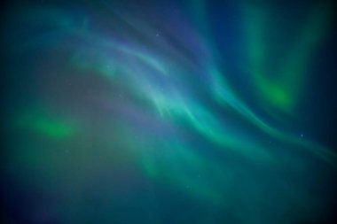 Kutup Dairesi 'nde kışın gökyüzünde parlayan Aurora Borealis ya da Kuzey Işıkları mistik