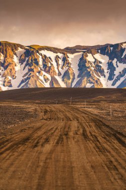 İzlanda kırsal kesiminde volkanik dağlı boş toprak yol.