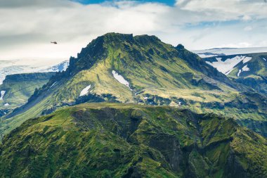 Verimli engebeli volkanik dağın dramatik manzarası ve İzlanda 'nın Thorsmork şehrinde yaz mevsiminde İzlanda' nın dağlarında uçan gezici helikopter turu.