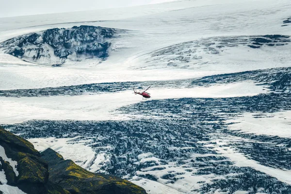 Sightseeing helicopter tour flying through glacier mountain with snow covered in Icelandic highlands at Iceland