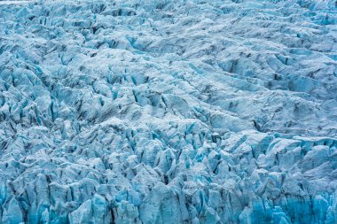 İzlanda, Vatnajokull Ulusal Parkı 'ndaki Fjallsarlon buzdağı gölünde engebeli, dokulu, doğal mavi bir buzdağı.