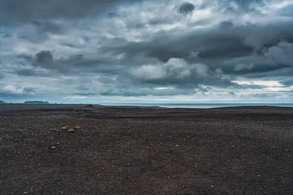 Dark moody sky over wilderness area and black sand beach in Solheimasandur, Iceland