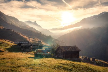 Dağların ve kırsal kesimlerin üzerinde güzel altın bir gün doğumu sonbaharda Findeln, Zermatt, İsviçre 'de tepede bir kamyon.