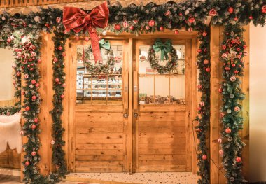 Ahşap kapı, kafenin önünde noel ağacı, balo, kurdele ile süslenmiş. Noel Festivali boyunca kutlama
