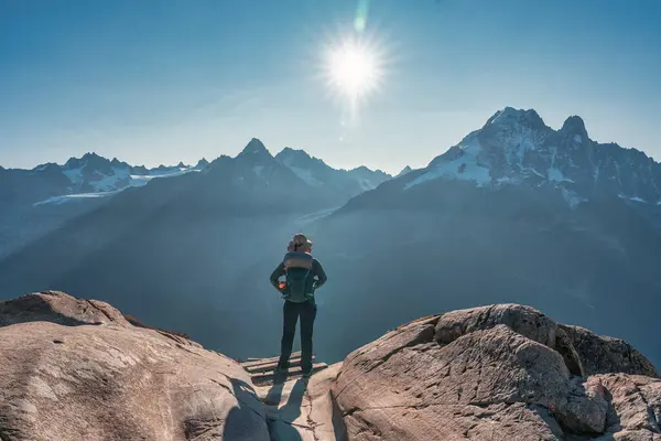 Achievement of female backpacker standing with enjoying the Mont Blanc mountain range view during trail of Lac Blanc, French Alps, France