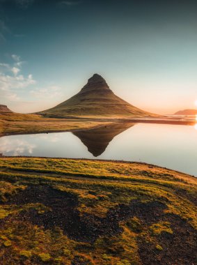 Kirkjufell volkanik dağının güzel hava manzarası İzlanda 'nın Snaefellsnes yarımadasında sonbahar sabahları gölü yansıtır.