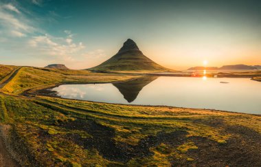 Kirkjufell volkanik dağının güzel hava manzarası İzlanda 'nın Snaefellsnes yarımadasında sonbahar sabahları gölü yansıtır.