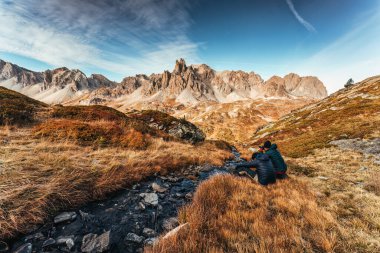 İki erkek fotoğrafçı, Fransa 'nın Hautes Alpes şehrinde, Claree Vadisi' nde, Fransız Alpleri arasında sonbaharda büyük Des Cerces ile fotoğraf çekiyor.