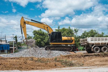 Kazıcı ya da kepçe kepçesi toprağı hareket ettiriyor ve inşaat alanında toprak ve taş kazıyor