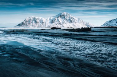 Norveç 'in Lofoten Adaları' nda kışın karlı dağları ve çizgili kum dalgalarıyla güzel Skagsanden plajı