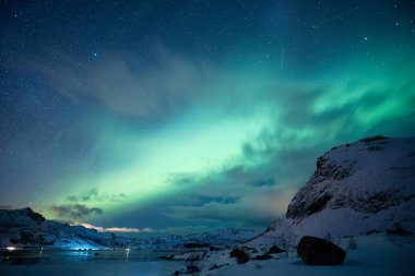 Aurora Borealis 'in güzel manzarası, Norveç, Lofoten Adaları' ndaki Kuzey ışıkları Kuzey Kutup Okyanusu 'ndaki karlı dağın üzerinde parlıyor.