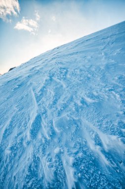 Kar fırtınasında gün ışığında karlı zirve dağı