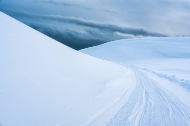 Karla kaplı beyaz buzul dağı ve İzlanda 'da kışın zirvede kar motosikletli patika
