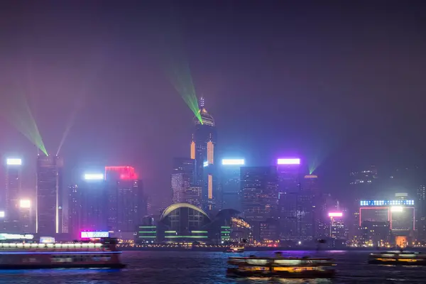 stock image Beautiful night scene cityscape of colorful illuminated business skyscraper building with laser lighting show on Victoria Harbour in foggy day at Hong Kong island 