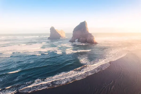 stock image Aerial view of Picturesque sunrise shining over Wharariki beach and archway islands on Tasman sea at West of cape farewell, New Zealand