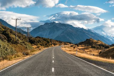 Sonbaharda Yeni Zelanda 'da mavi gökyüzü ile birlikte Cook Dağı' na giden asfalt yol.