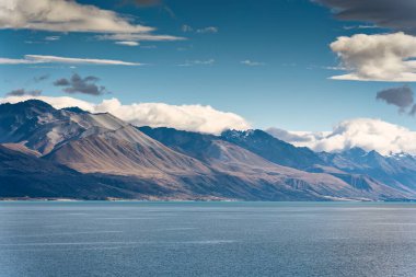 Yeni Zelanda 'da güneşli bir günde Pukaki Gölü' nde mavi gökyüzü olan Rocky Dağı