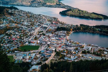 Wakatipu Gölü 'yle aydınlatılmış Queenstown' un ve Yeni Zelanda 'da sonbaharda yol manzarası.