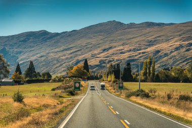 Sonbahar ve sonbahar aylarında Yeni Zelanda 'nın Güney Adası' nda asfalt yolda araba yolculuğu.