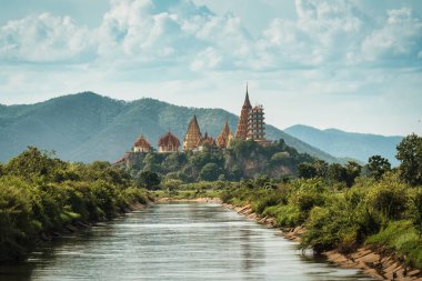 Famous place of Wat Tham sua , Tiger Cave temple on hill with irrigation canal on sunny day at Kanchanaburi, Thailand clipart