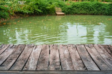 Tropikal bahçedeki balık havuzunda eski kahverengi ahşap balkon.