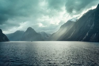 Milford Sound 'un görkemli manzarası. Fjord Dağı' nda güneş ışığı, şelale ve Yeni Zelanda Fiordland Ulusal Parkı 'nda gezinti.