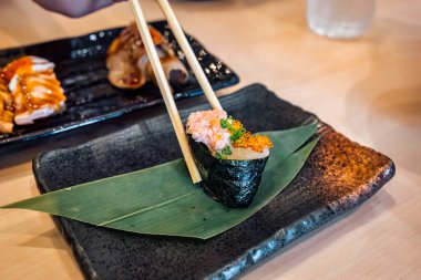 Çubukları, ton balıklı deniz yosunu suşisi ve Japon restoranındaki seramik tepside yumurtlamak için kullan.