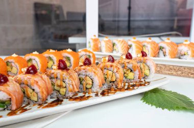 Seramik tepside çeşit çeşit somon suşisi ve sebze, Japon restoranında iştah açıcı yemek.