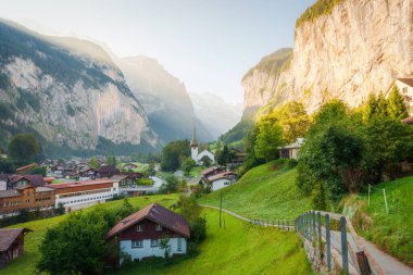 Lauterbrunnen geleneksel dağ köyünün ünlü kilisesi ve Lauterbrunnen 'deki Staubbach Şelalesi' nin manzarası. İsviçre 'nin Bern Kantonu' nda.