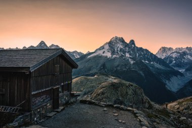 Fransa 'nın Haute Savoie kentindeki Fransız Alpleri' nde sabah zirvesinde Mont Blanc kalabalık ve ahşap barakalı görkemli manzara.