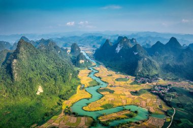 Phong Nam Vadisi 'nin pirinç tarlası ve nehir manzarası Cao Bang, Vietnam kırsalındaki geleneksel köy boyunca akar.