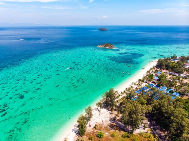 Yazın Tayland 'ın Satun kentindeki sahil kenarında mercan resifi ve geleneksel teknesi olan güzel, canlı tropikal deniz manzarası.