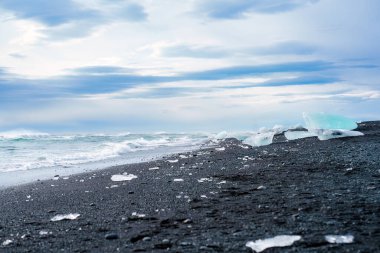 Buzdağının eridiği güzel elmas plajı İzlanda 'nın güneyinde yaz mevsiminde siyah kumsalda parlıyor.