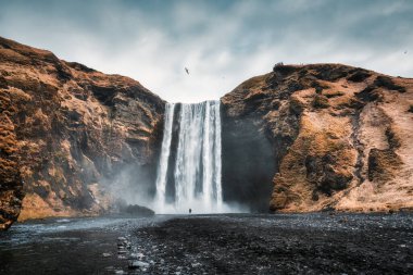 Güçlü Skogafoss şelalesinin dramatik manzarası İzlanda 'nın güneyindeki sonbaharda volkanik dağdan akıyor.